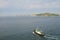 Tugboat in the sea against the backdrop of the cityscape. Tugboat await large cargo ship to assist tugboats, maneuvering, mooring