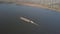 A tugboat ship pushes a barge upstream of the river to transport bulk materials. Aerial photography with a quadcopter or