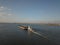 A tugboat ship pushes a barge upstream of the river to transport bulk materials. Aerial photography with a quadcopter or