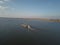 A tugboat ship pushes a barge upstream of the river to transport bulk materials. Aerial photography with a quadcopter or