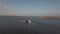 A tugboat ship pushes a barge upstream of the river to transport bulk materials. Aerial photography with a quadcopter or