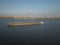 A tugboat ship pushes a barge upstream of the river to transport bulk materials. Aerial photography with a quadcopter or