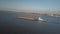 A tugboat ship pushes a barge upstream of the river to transport bulk materials. Aerial photography with a quadcopter or