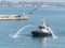 Tugboat welcoming a cruise liner in the harbor.