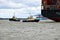 Tugs lead out a container ship from the port from Felixstowe UK