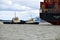 Tugs lead out a container ship from the port from Felixstowe UK