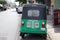 Tuk Tuk or Taxi tricycle in green color on the road, Lifestyle of traffic in Phnom Penh. It is a three-wheeled motorized vehicle