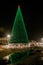 Tula, Russia, 15.12.2020. The city`s main Christmas tree burns with green lights on the square and is reflected in puddles