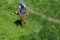 TULA, RUSSIA - MAY 19, 2020: Russian official lawnmower worker man cutting green grass with two-cycle engine string