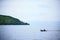 Tulas island as background of a small fisherman boat sail in Toba Lake, North Sumatra, Indonesia.