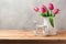 Tulip flowers bouquet and retro rocking horse toy on wooden table