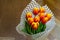 Tulip flowers covered with white paper standing on wooden floor. Best gift for holiday. Concept of love, tenderness, copy space,