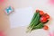 Tulips, card and gift box on beige background.