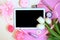 Tulips, cosmetics and black mockup tablet, flat lay