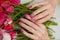 Tulips design nail art, manicured fingernails on spring flowers background. Beauty concept