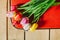 Tulips in red suitcase. wooden background