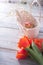 Tulips on a wooden background with marshmallows in a wooden basket