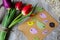 Tulips on wooden tray background. Invitation postcard for mother`s day or international women`s day. Spring paper colorful birds