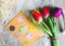 Tulips on wooden tray background. Invitation postcard for mother`s day or international women`s day. Spring paper colorful birds