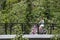 Tulsa Oklahoma USA 5 26 2019 Mother and tiny daughter both on pink bicycles cross bridge surrounded by lush foliage