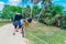 TULUM, MEXICO - JANUARY 10, 2018: Unidentified people walking and trying to feed a wild iguana close to the Mayan Ruins