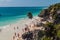 TULUM, MEXIO - FEB 29, 2016: Tourists at the beach under the ruins of the ancient Maya city Tulum, Mexi