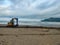 Tulungagung, Indonesia - 08-03-2023: Excavator is cleaning the beach from rubbish that litters the beach
