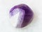tumbled amethyst gem stone on white