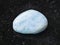 tumbled aquamarine (blue beryl) gem stone on dark