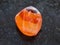 tumbled carnelian gem stone on dark background