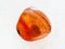 tumbled carnelian gem stone on white marble