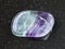 tumbled Fluorite gem stone on dark background