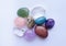 Tumbled gems of various colors. Amethyst, rose quartz, agate, apatite, aventurine, rock crystal on white background