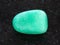 tumbled green Aventurine gem stone on dark