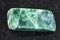 tumbled green jadeite stone on dark background