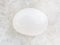 tumbled milky quartz gemstone on white marble