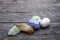 Tumbled pastel cabochon crystal gemstones on a weathered oak table surface, blue lace agate, chrysoprase, citrine, pink calcite