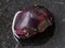 tumbled red garnet gemstone on dark background