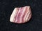 tumbled rhodochrosite gem stone on dark