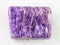 tumbled slab of charoite gemstone on white