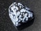 Tumbled snowflake obsidian gem stone on dark