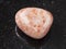 tumbled sunstone (heliolite) gem stone on dark