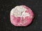 tumbled Thulite gemstone on dark background