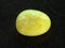 tumbled yellow calcite gemstone on dark