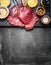 Tuna fish steaks with ingredients for grill or cooking on dark vintage background, top view
