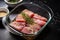 tuna steaks marinating in a glass dish, covered in sesame seeds