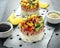 Tuna sushi stacks with mango, cucumber, tomatoes salsa served with balsamic vinegar, nigela ans sesame seeds