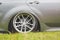 Tuned alloy wheels with a wide rim on an lowered silver car standing on the grass