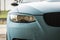 Tuned car headlight detail. Macro view of modern blue car