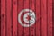 Tunisia flag depicted in bright paint colors on old wooden wall. Textured banner on rough background